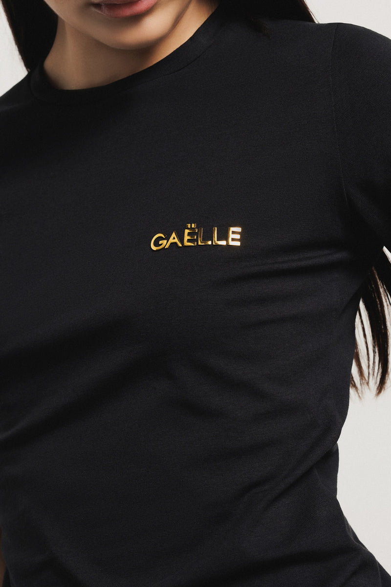 T-shirt paricollo in bielastico con logo oro lato cuore • Nero - Gaëlle Paris